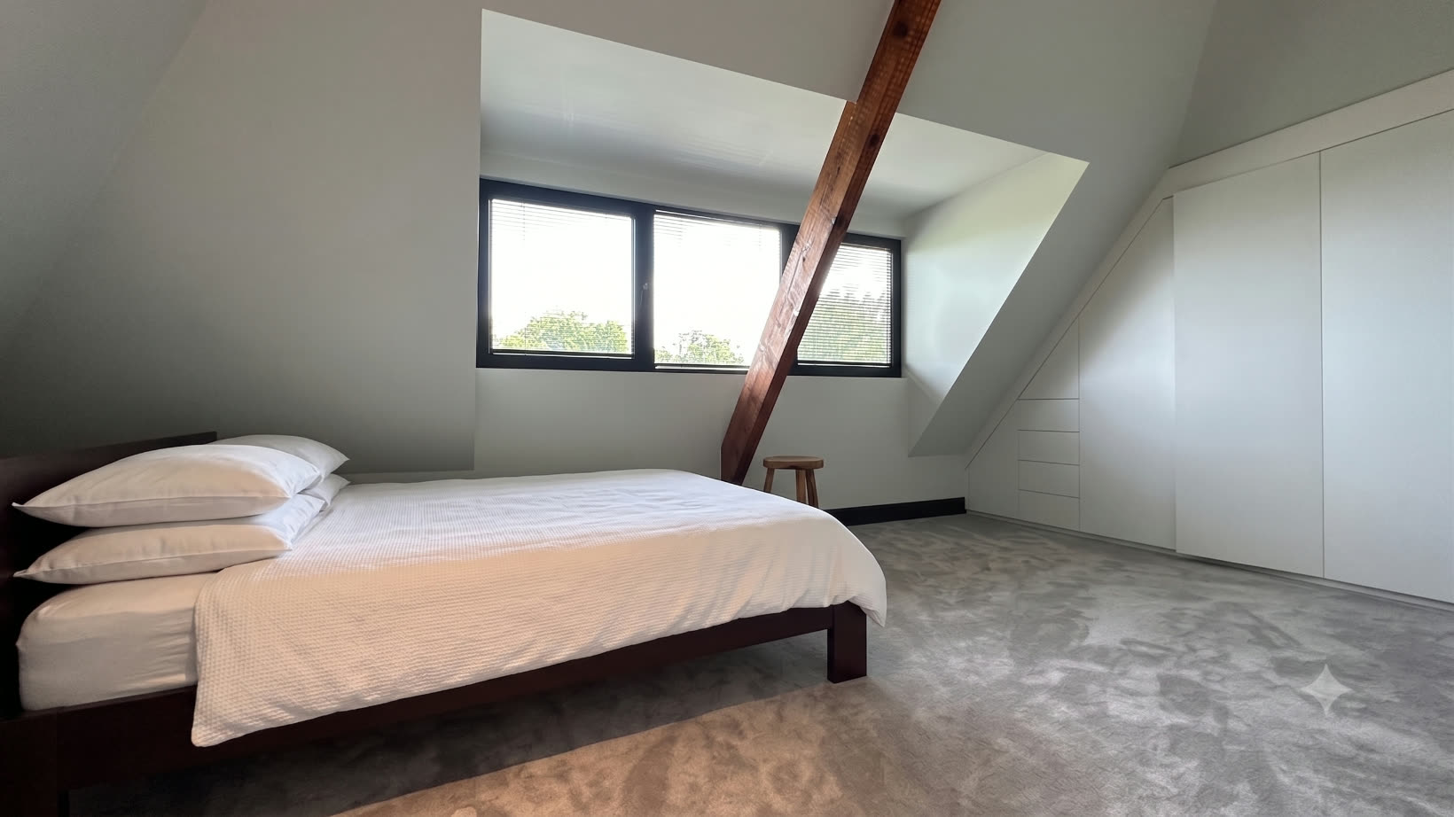 Attic bedroom with an exposed timber beam and built-in wardrobes