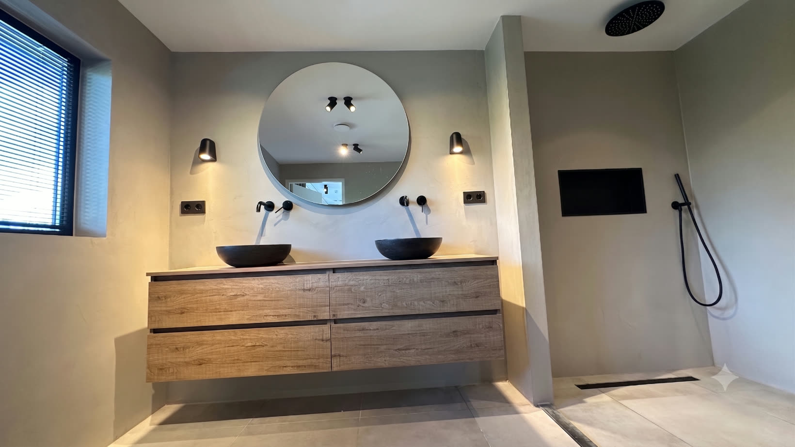 Master en-suite bathroom with double vanity and round mirror