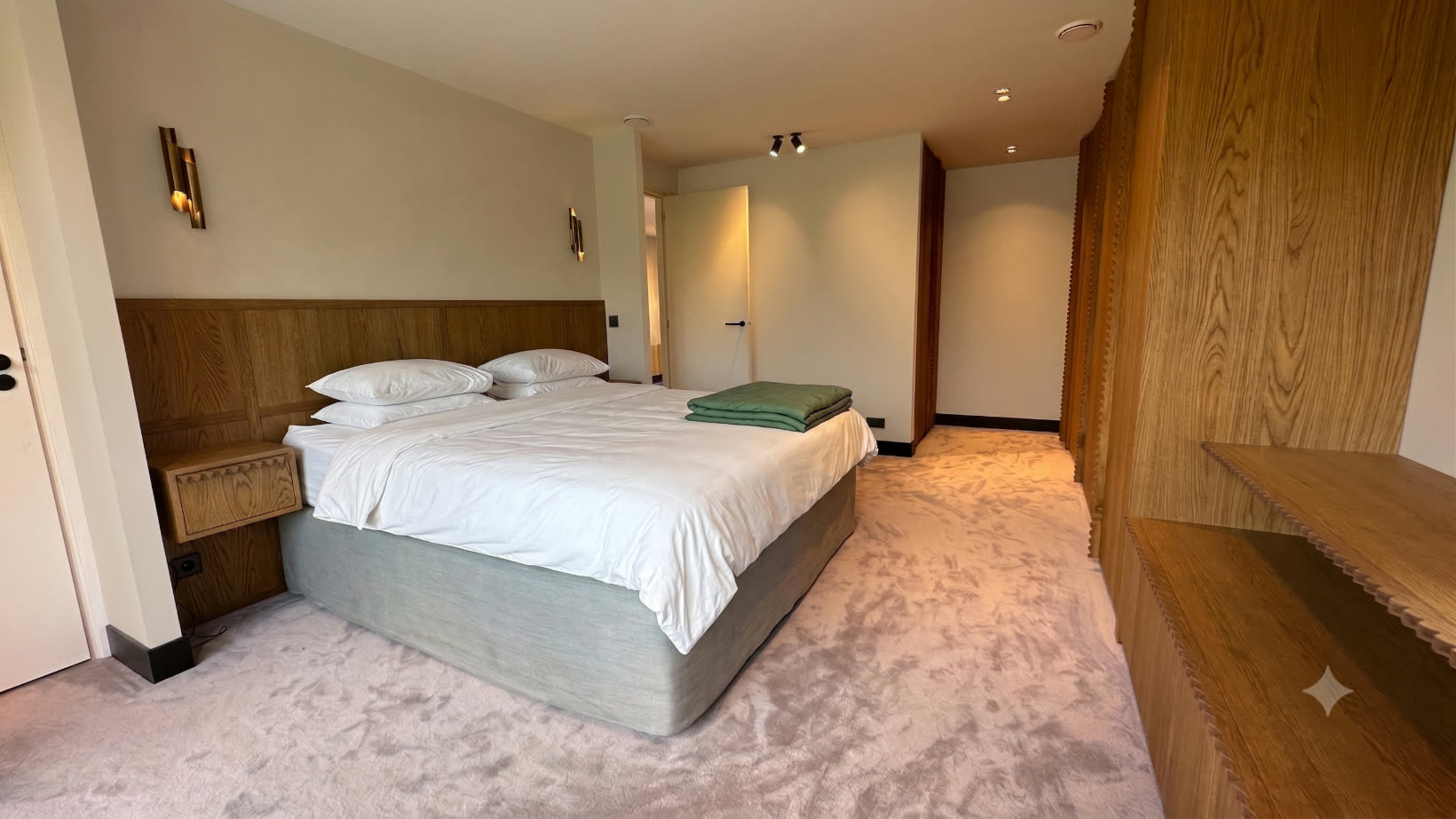 Master bedroom with oak headboard and a full wardrobe wall